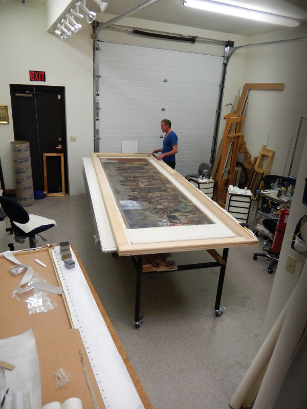 In the studio of Steven Prins & Company, Cyrus McCray checks the square on the oversize stretcher that supported the canvas throughout its treatment after removal from the panel. Photograph courtesy Steven Prins & Company.