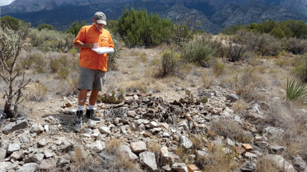 Sandia/Tijeras SiteWatch volunteer Lee Riley documents a site in the Sandia Mountains. Photograph courtesy Sandra Arazi-Coambs.
