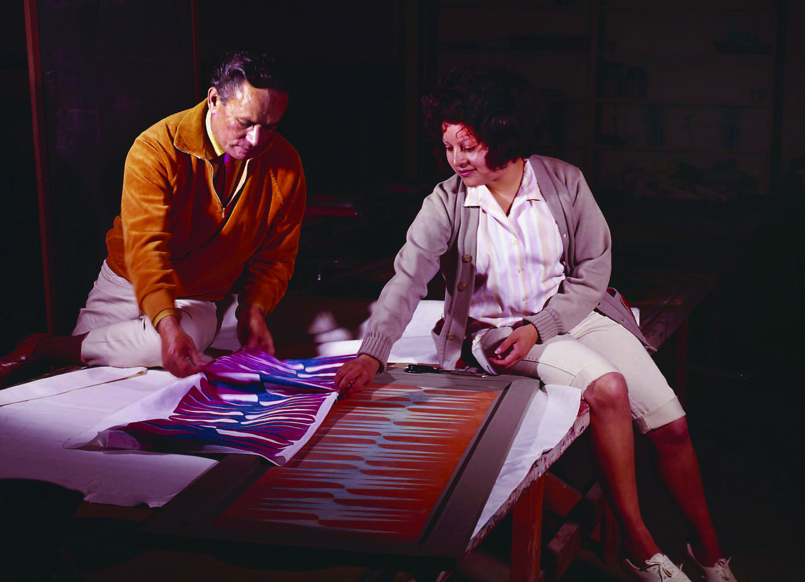 Lloyd Kiva New in the textile-printing studio with an IAIA student, ca. 1965. Photograph by Kay V. Wiest. Courtesy of Kay V. Wiest Collection, IAIA Archives, Santa Fe, New Mexico.