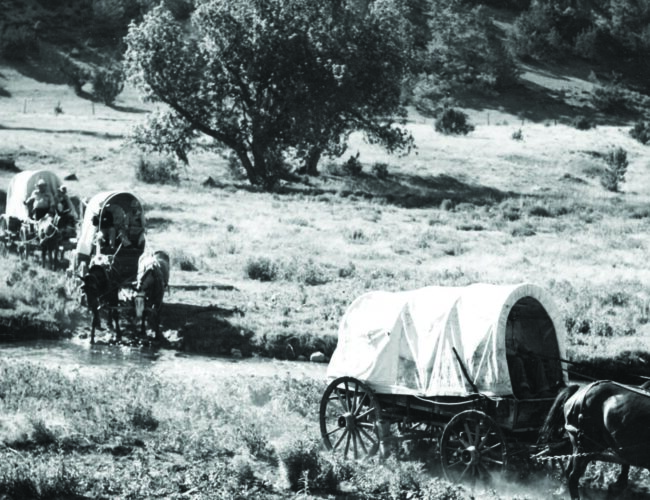 A latter-day wagon train crossing an unidentified stream in New Mexico. Photograph by the New Mexico Tourism Bureau, ca. 1940. Palace of the Governors Photo Archives (NMHM/DCA), Neg. No. 128733.