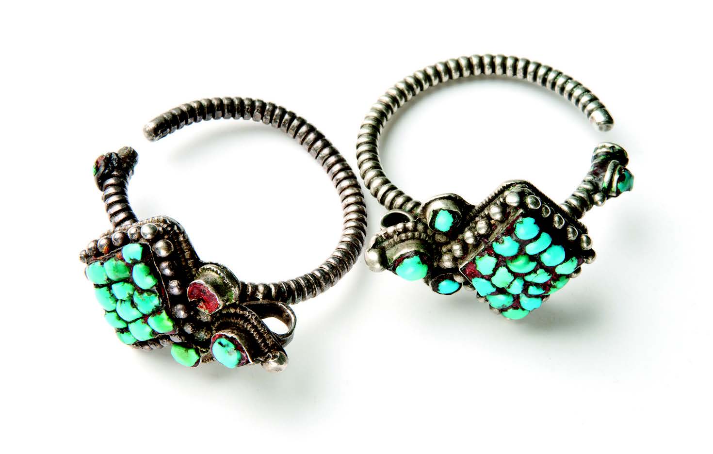 Pair of earrings (probably men’s). Large and/or heavy earrings such as these are tied into the hair by a string, which attaches to the earring by the loop behind the turquoise stones. Silver, turquoise, and wax. Tibet, early twentieth century. Museum of International Folk Art, gift of Cameron Peters (A.2013.7.1ab). Photograph by Blair Clark.