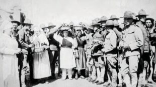 The Red Cross and Native American women giving “the boys” fruit, cigarettes, and handkerchiefs, ca. 1918. Courtesy of the Center for Southwest Research, UNM, Number 000-885(8)-0012.