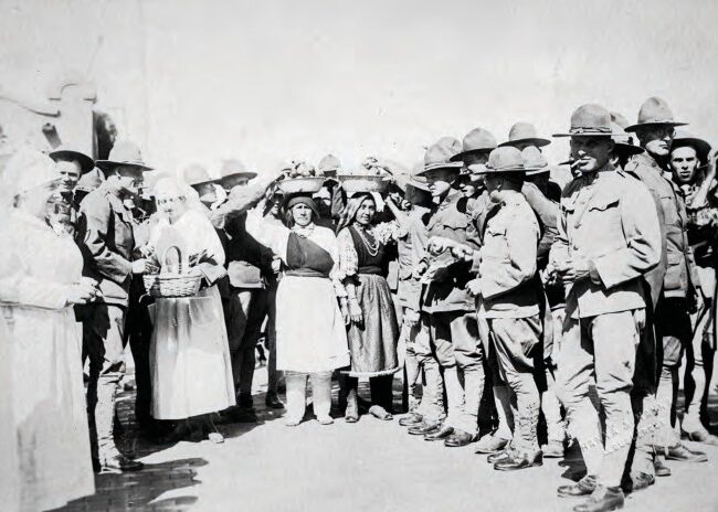 The Boys The Red Cross and Native American women giving “the boys” fruit, cigarettes, and handkerchiefs, ca. 1918. Courtesy of the Center for Southwest Research, UNM, Number 000-885(8)-0012.