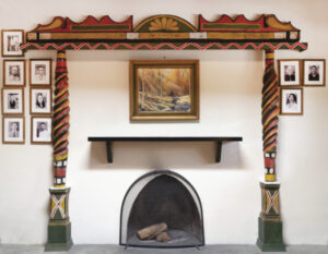 A fireplace, framed by carved columns, adds warmth to the Billiard House at El Delirio. Photograph by Simone Frances, 2020.