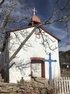 The Nuestra Señora de Luz façade features a small window set in the front gable and a bell canopy topped with a cross. Photograph by Melanie McWhorter, 2020.
