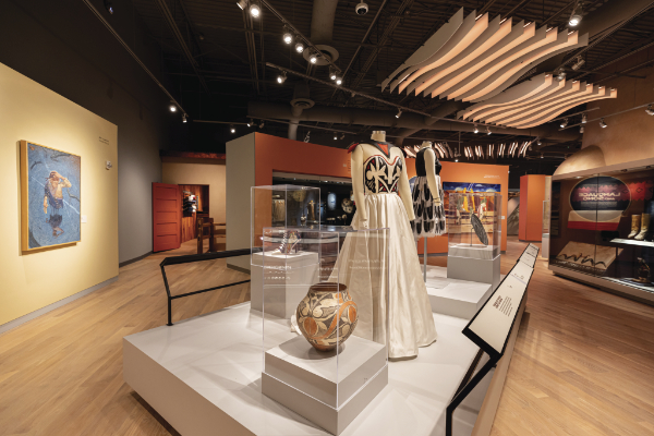 A gown by Loren Aragon (Acoma), inspired by the Acoma or Laguna pot seen in the foreground, is one of the focal points in the Arts section.