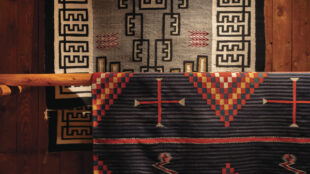 Foreground: Unknown artist (Navajo), Hubbell Trading Post rug, ca. 1800-1890. Commercial Germantown wool. 81 7 8 × 62 inches. Gift of Mr. and Mrs. Edward H. Tatum. MIAC Collection: 36197/12. Background: Unknown artist (Navajo), Two Grey Hills rug, ca. 1910-1920. Handspun wool, aniline dye. 88 3 5 × 54 ¾ inches. Gift of the Santa Fe Opera. MIAC Collection: 56595/12.