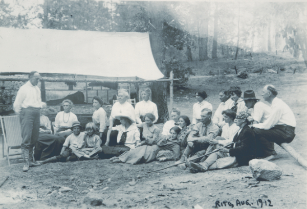 The 1912 Summer Session at the Rito de los Frijoles. Included here are Edgar Lee Hewett (standing, at left) and Charles Lummis (seated, with bandana and cigar, third from right). It is probable that Elizabeth Deuel is the woman seated to his right, next to School patron Frank Springer. Courtesy Autry Museum of the American West.