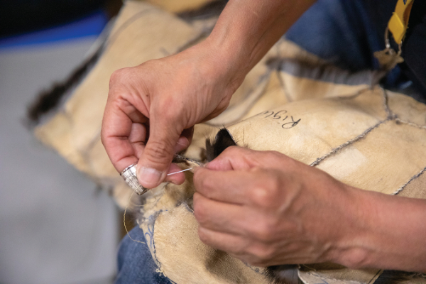 Jenny Irene Miller, Bobbie Gomez sewing, Qat ut: Northwest Arctic Trade Fair, Qikiqta ruk (Kotzebue), 2019.