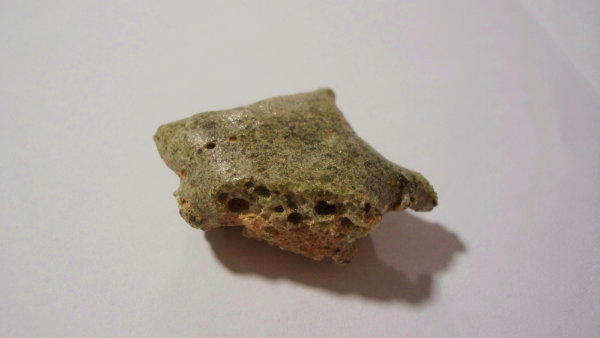 A piece of Trinitite, a glass-like matter that developed from desert sand by the explosion of the first atomic bomb at the Trinity Test Site. Photograph by Scherff.